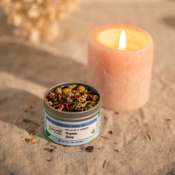 Organic Sleep, Loose Leaf Herbal Tea Tin - Sleepytime Tea - Sleep, Calming, Relaxing, Naturally Caffeine-free - Heavenly Tea Leaves - Candle and organic tea packaging on a textured surface with blurred background